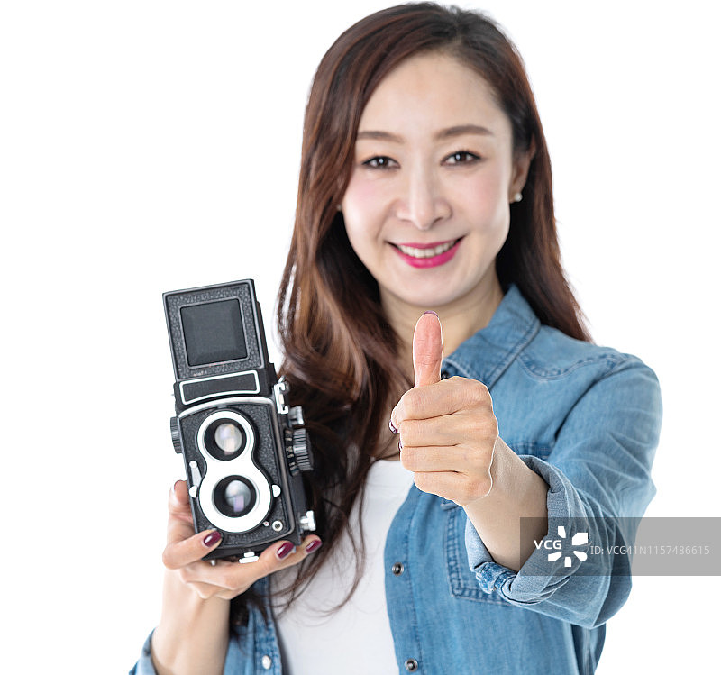 拿着老式相机，竖起大拇指的女人图片素材