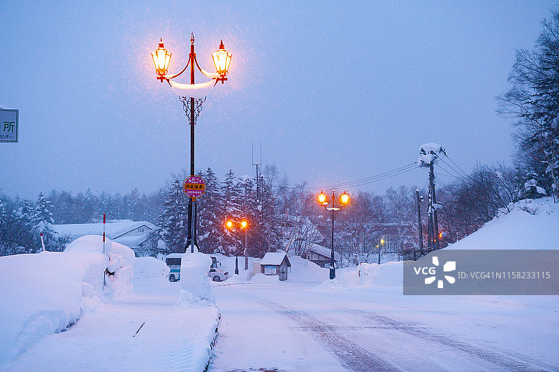冬夜灯柱路灯在大雪中。图片素材