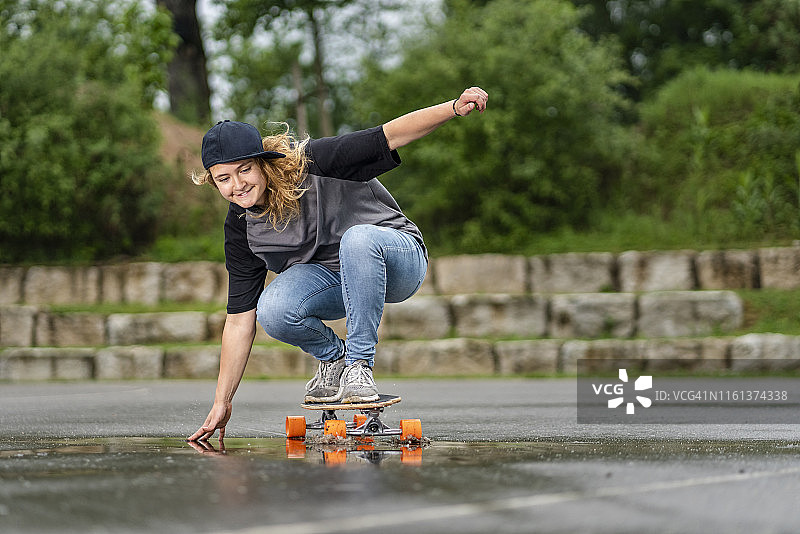 年轻女子在滑板上保持平衡图片素材