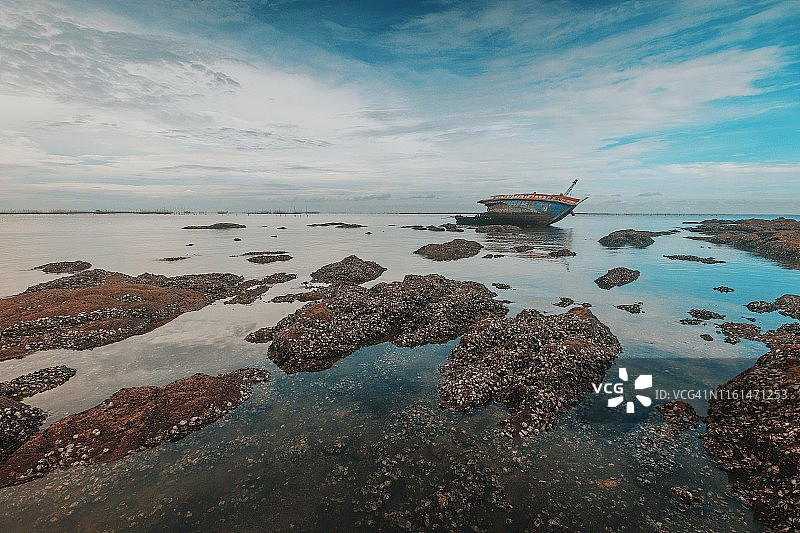 泰国，日出时，海滩上的海难船图片素材