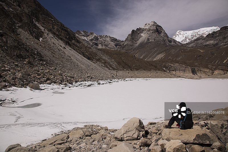 坐在悟空附近的第五湖旁的人，珠峰大本营通过悟空徒步，尼泊尔图片素材