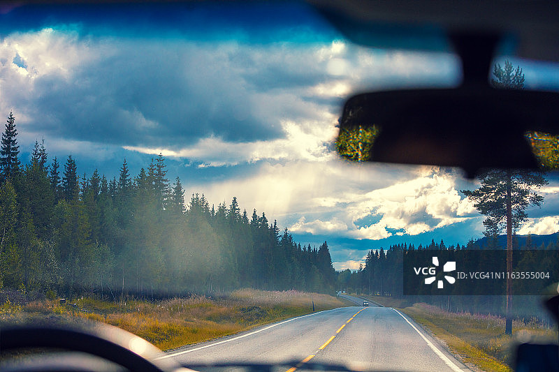 在山路上开车。从挡风玻璃上看到挪威美丽的自然风光图片素材