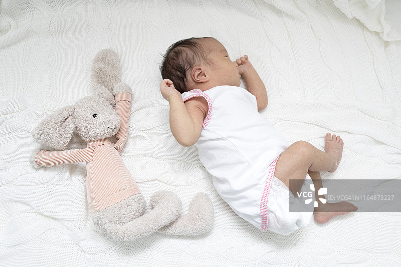 新生儿和玩具一起睡觉图片素材