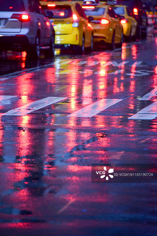 在纽约潮湿的路面上，汽车红绿灯的反光图片素材