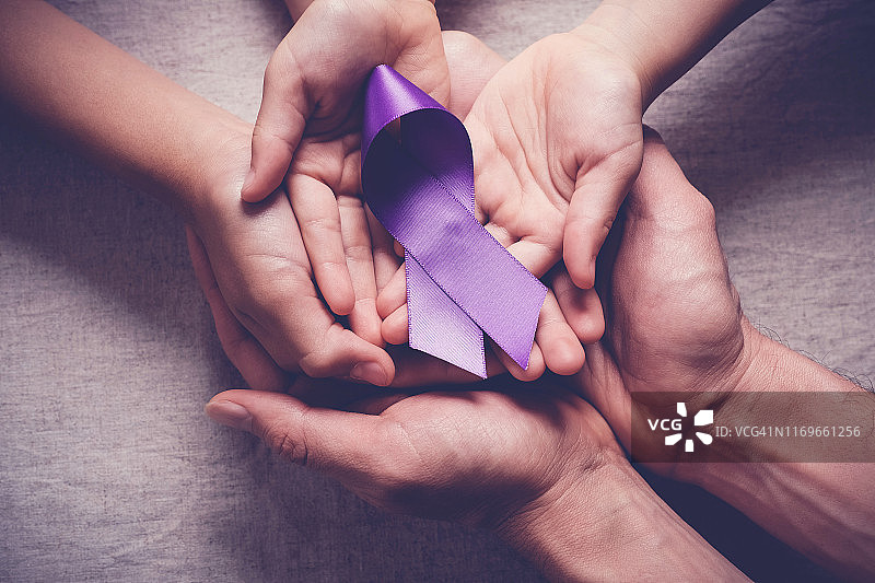 成人和儿童手握紫丝带，老年痴呆症，胰腺癌，癫痫意识，世界癌症日图片素材