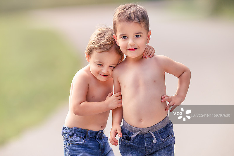 3岁的异卵双胞胎在夏天拍摄时相互拥抱图片素材