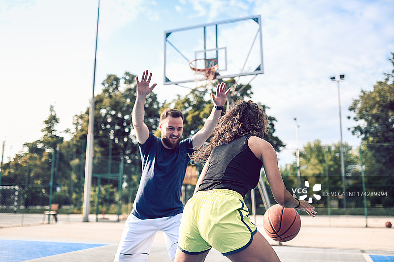 男性和女性正在进行一场篮球友谊赛图片素材