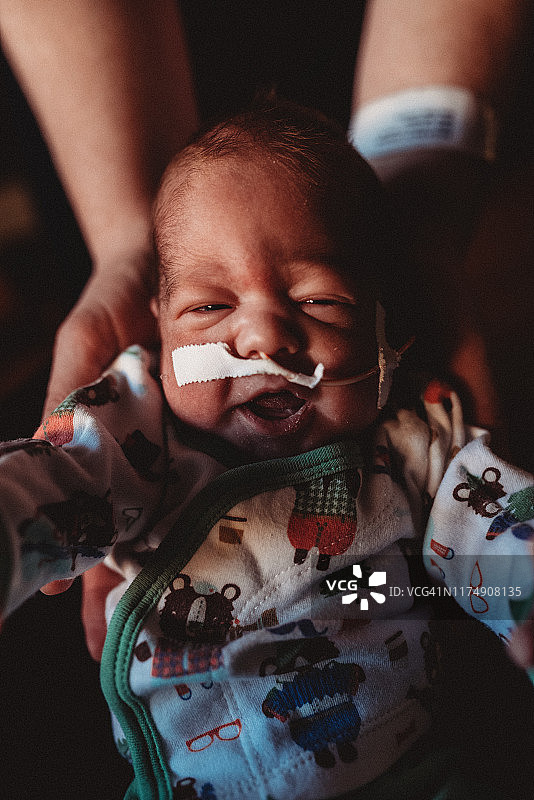 微笑的29周早产儿是由母亲抱在医院的NICU图片素材