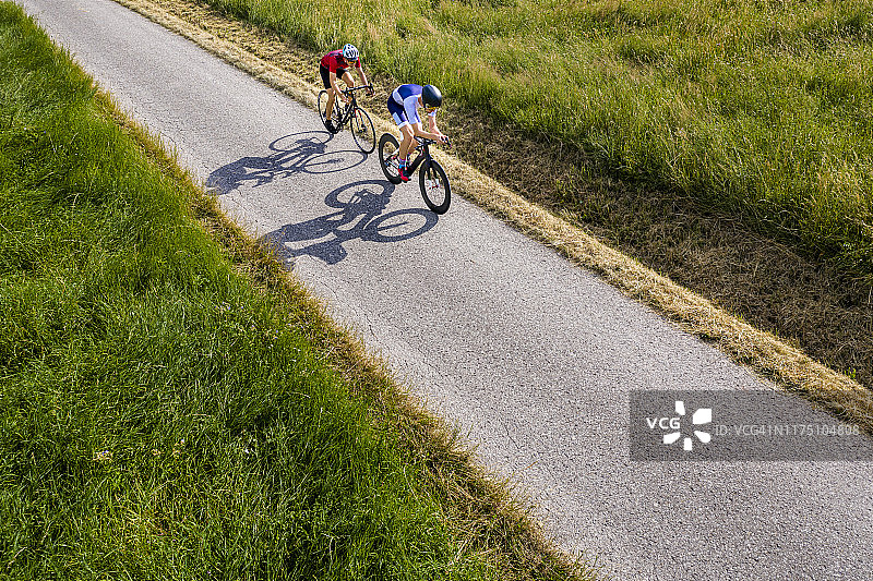 德国乡村公路上骑自行车的铁人三项运动员图片素材