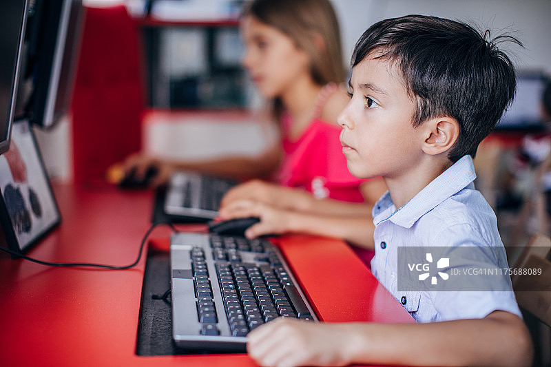 男孩和女孩在小学使用电脑图片素材