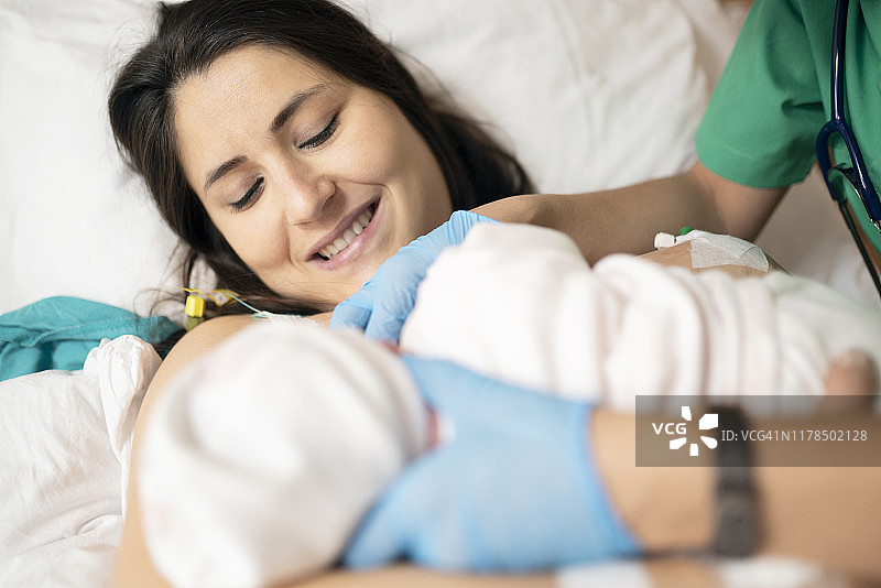 母亲在病房母乳喂养新生儿，第一次母乳喂养图片素材
