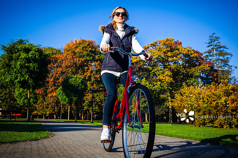 城市自行车-在城市公园骑自行车的妇女图片素材