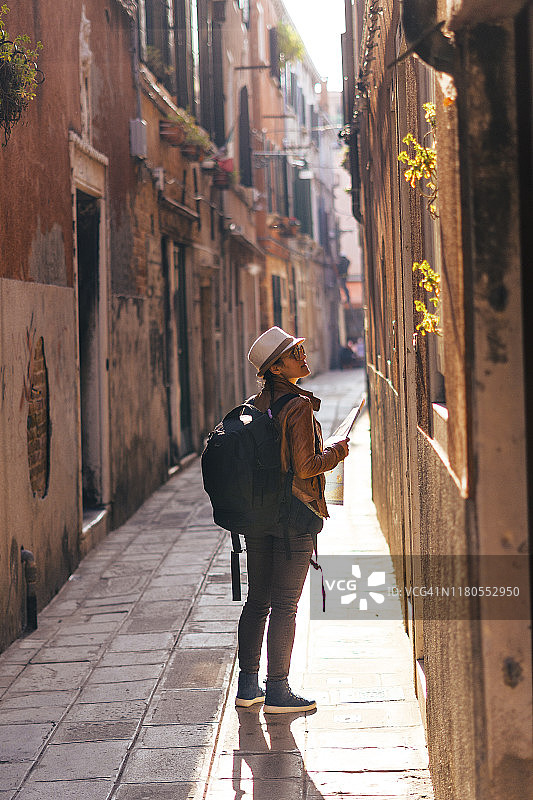 幸福地迷失在威尼斯的小街上。意大利的浪漫之城。用网上打印的地图在威尼斯寻找隐藏的地方。图片素材