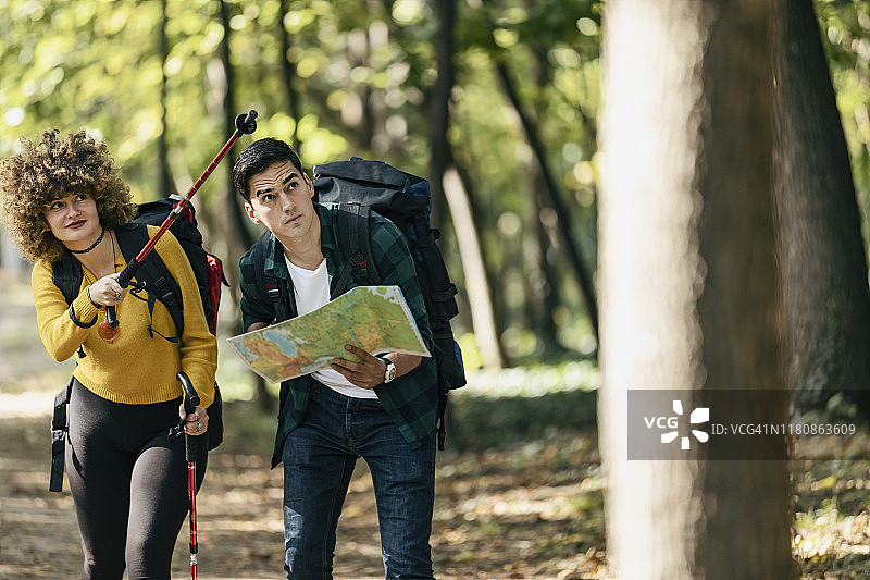 在森林里一起徒步旅行时，男人和女人在地图上寻找目的地的部分视图图片素材