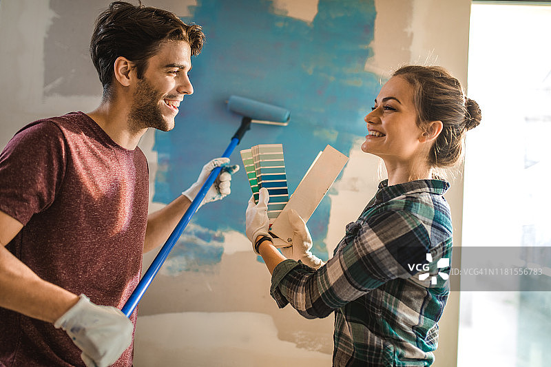 幸福的夫妇在为他们的墙选择正确的颜色时交流。图片素材