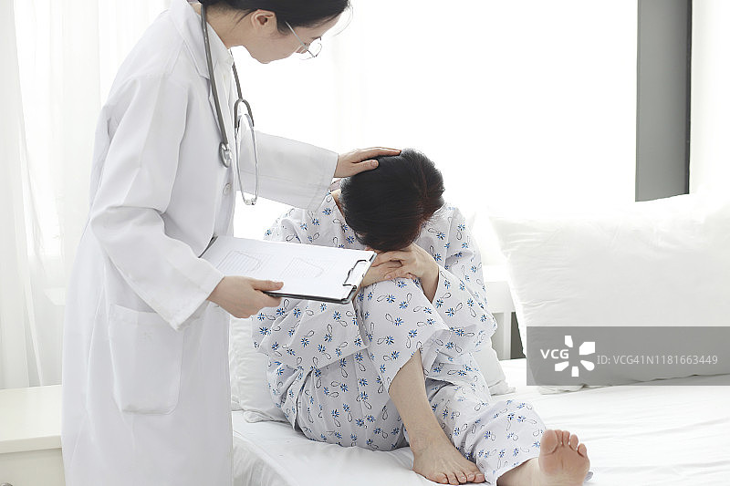 医生在床上检查病人的头痛图片素材