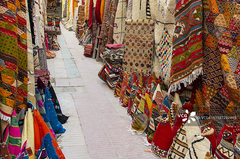摩洛哥地毯集市。在摩洛哥的Essaouira狭窄的街道上出售的彩色地毯图片素材