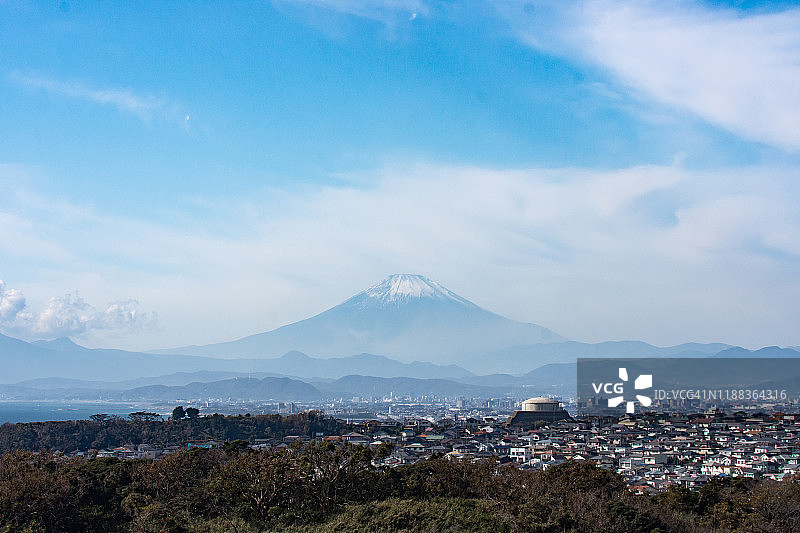 白雪皑皑的富士山和日本神奈川县海边的住宅区图片素材