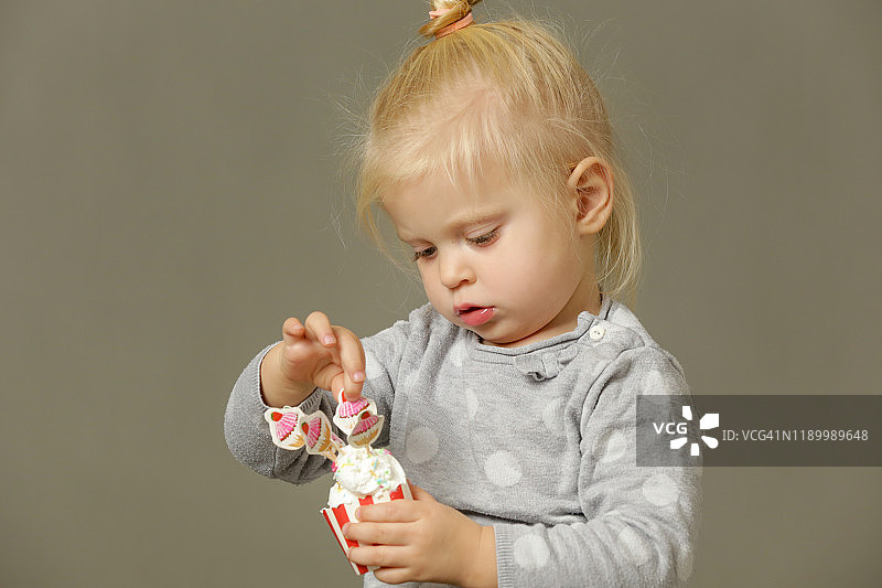 一个蹒跚学步的孩子正在吃奶油蛋糕图片素材