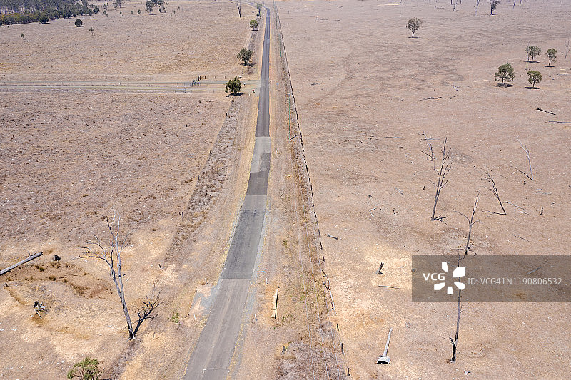 鸟瞰图干旱条件下干燥的土壤在农田上与一条道路通过中心图片素材
