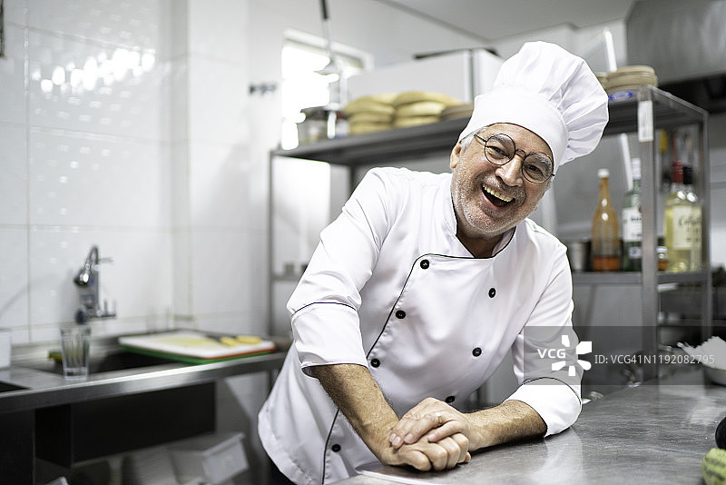 高级厨师在厨房微笑的肖像图片素材