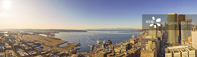 白天的西雅图全景，办公大楼和摩天大楼与摩天轮，普吉特湾，到达渡轮，商业滨水和奥林匹克山在远处。图片素材