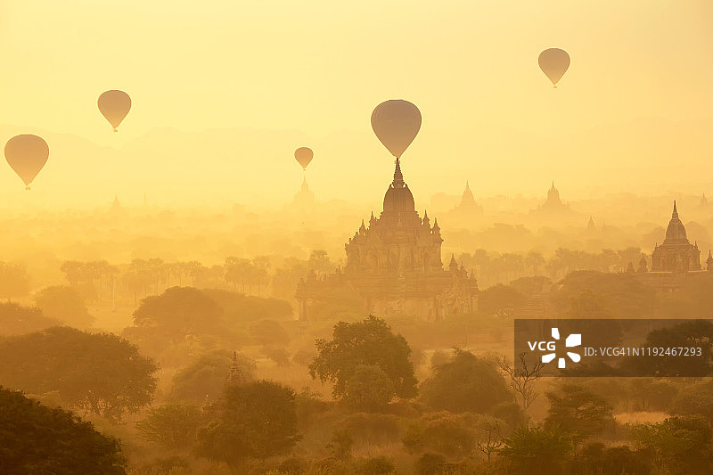 缅甸蒲甘平原夕阳下的宝塔景观和几个气球。蒲甘，曼德勒，缅甸。图片素材