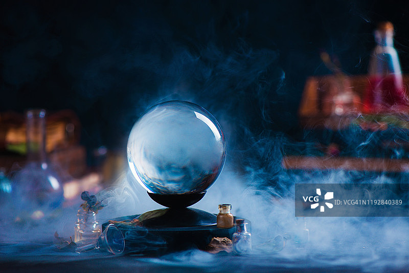 带有神秘设备和神秘烟雾的水晶球。具有复制空间的魔法标题图片素材
