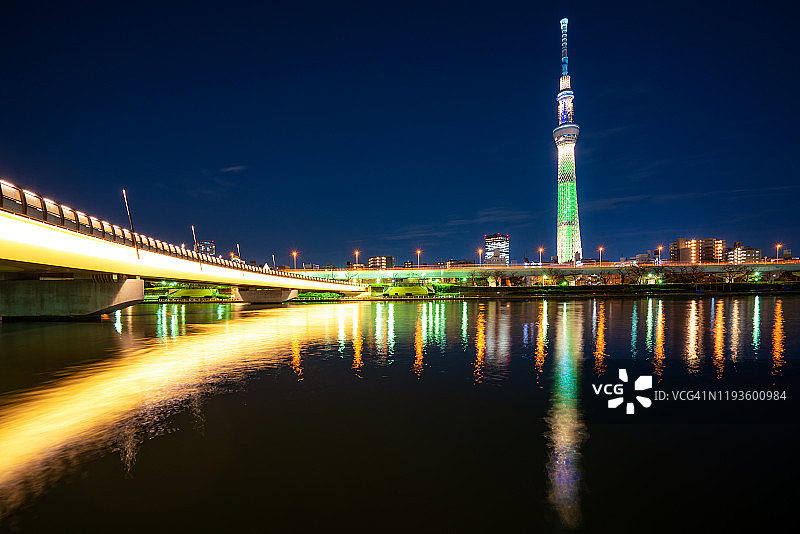 东京，日本的天际线在Sumida河与东京的天空树在夜间的背景。日本旅游，现代城市生活，或商业金融和经济概念图片素材