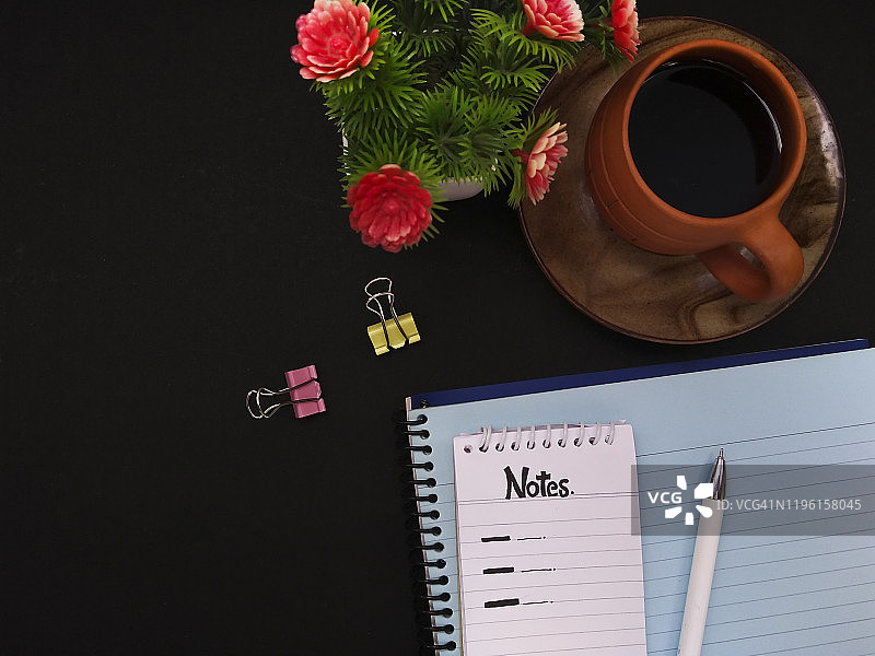 顶部螺旋记事本，日记本，钢笔，素描笔与咖啡杯和花盆。图片素材