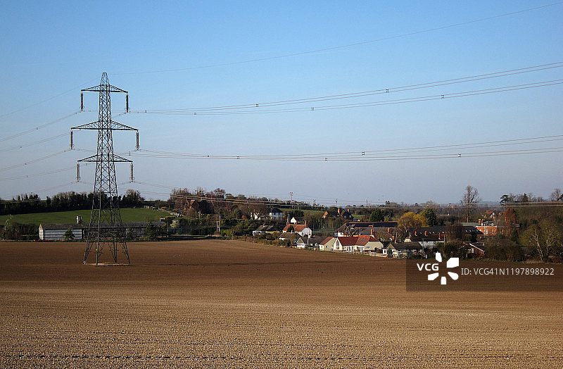 电塔和电缆经过一个村庄图片素材