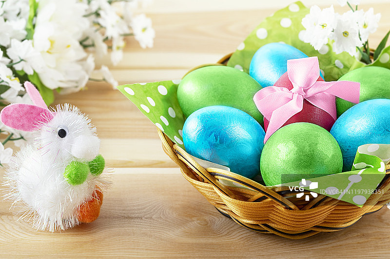 小玩具兔子在木制背景和篮子装饰鸡蛋图片素材