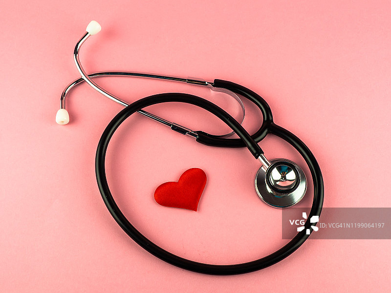 一个听诊器和一颗粉红色背景上的红心图片素材