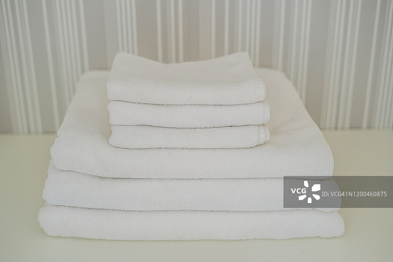 壁橱里一堆白色松软的毛巾。服务于酒店理念。洗衣图片素材