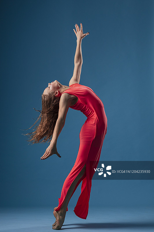 蓝色背景下红色裙子的舞者图片素材