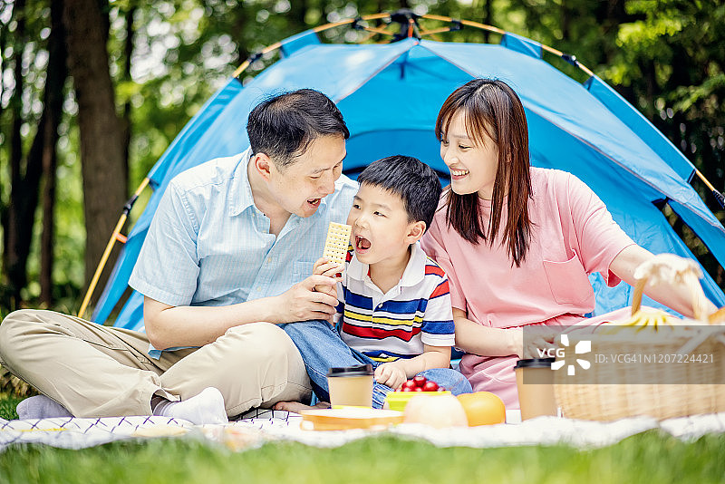 快乐的亚洲家庭在森林公园野餐图片素材