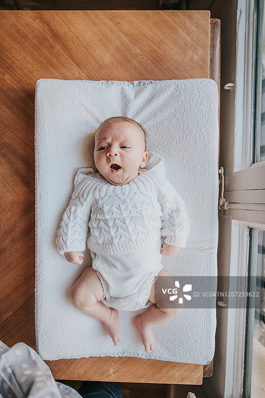 一个新生儿在换尿布台上的俯视图图片素材