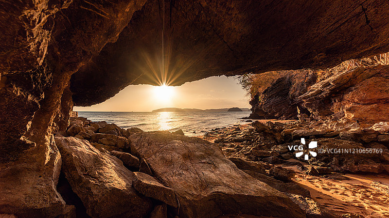 海岸洞穴框架美丽的日落风景在海滩上，奥南全景海景-甲米，泰国。旅游目的地及度假图片素材