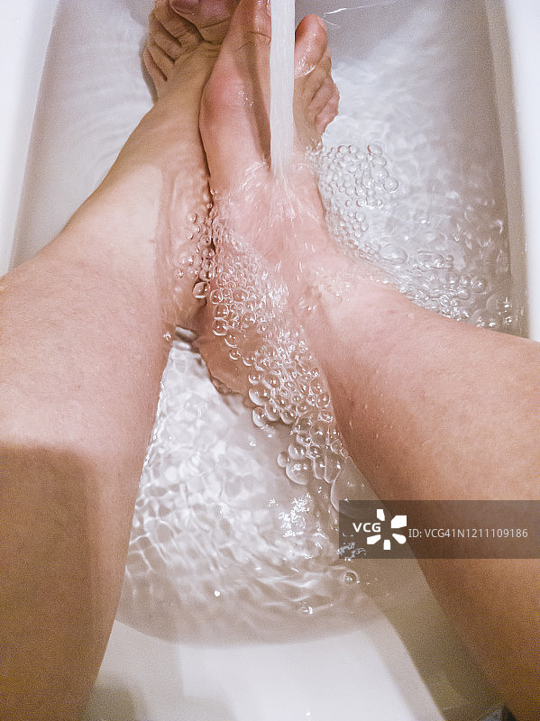 一个男人正在脚浴盆里泡脚图片素材