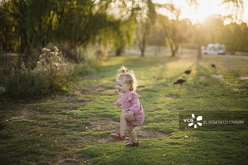 日落时分，小女孩在土路上玩耍图片素材