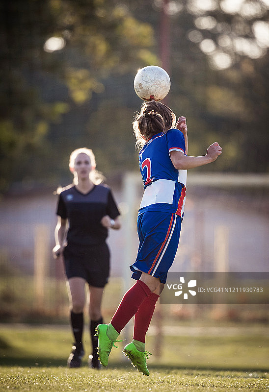 女子足球运动员在比赛中头球。图片素材