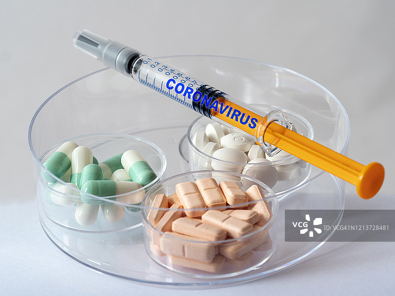 注射covid-19冠状病毒疫苗和治疗症状的药片。图片素材
