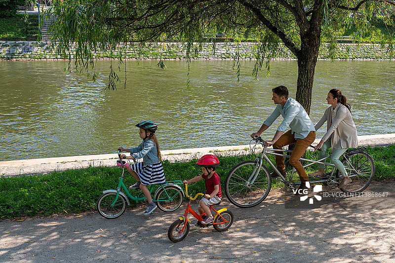 一个白人家庭在河边骑自行车图片素材