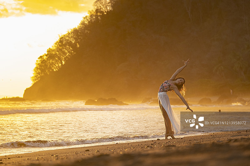 十几岁的女孩练习体操在海滨日落，雅克海滩，哥斯达黎加图片素材