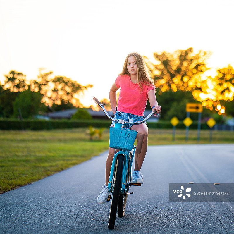 青少年在日落时骑自行车图片素材