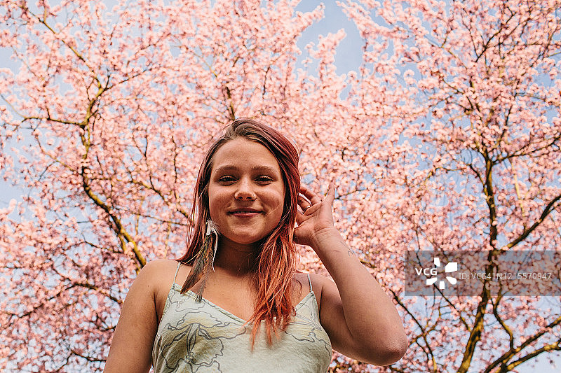 木兰树下的年轻女子微笑着图片素材