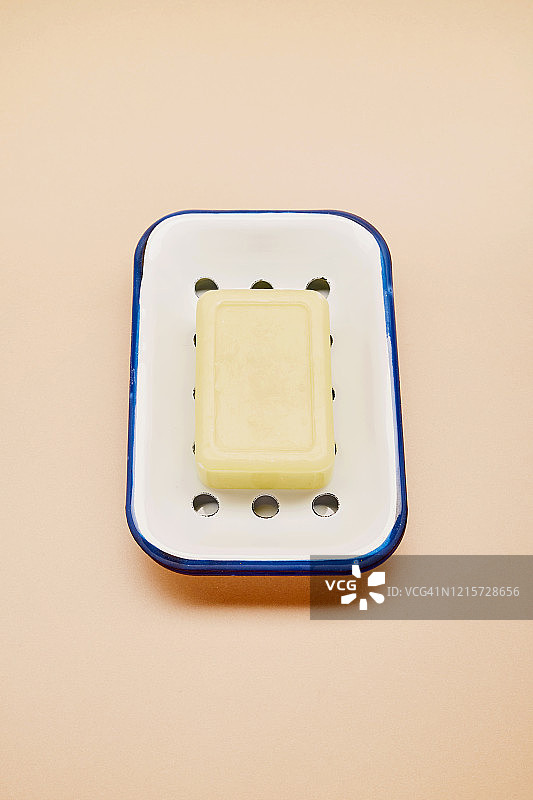 高角度的珐琅肥皂盘和肥皂为洗手米色的背景图片素材