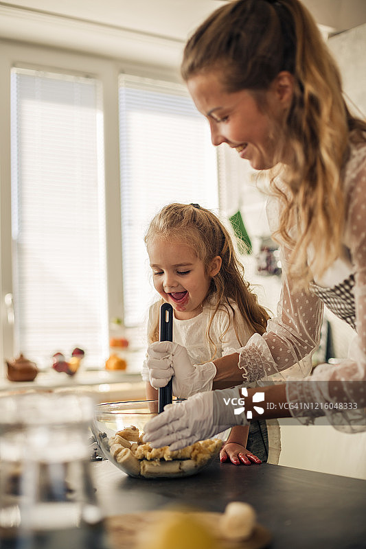 母亲和女儿有乐趣的时间，而粉碎原料的素食食谱图片素材