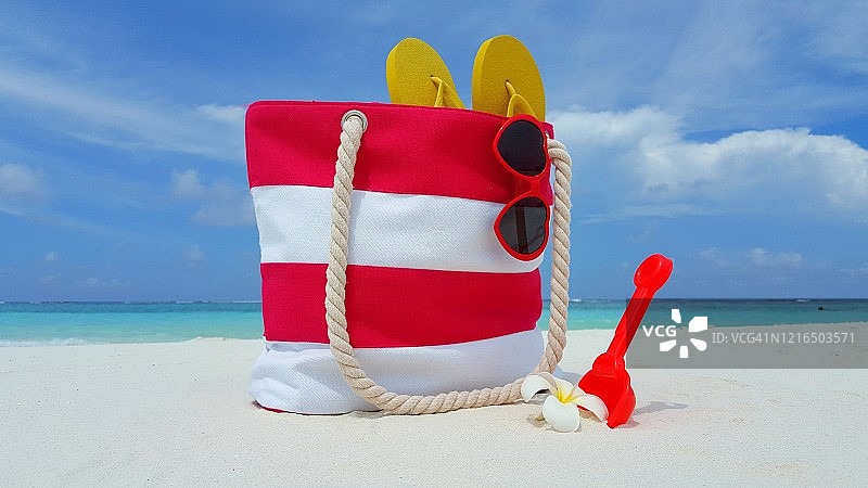夏日度假概念背景，沙滩包，太阳镜，人字拖在马尔代夫的海滩上图片素材