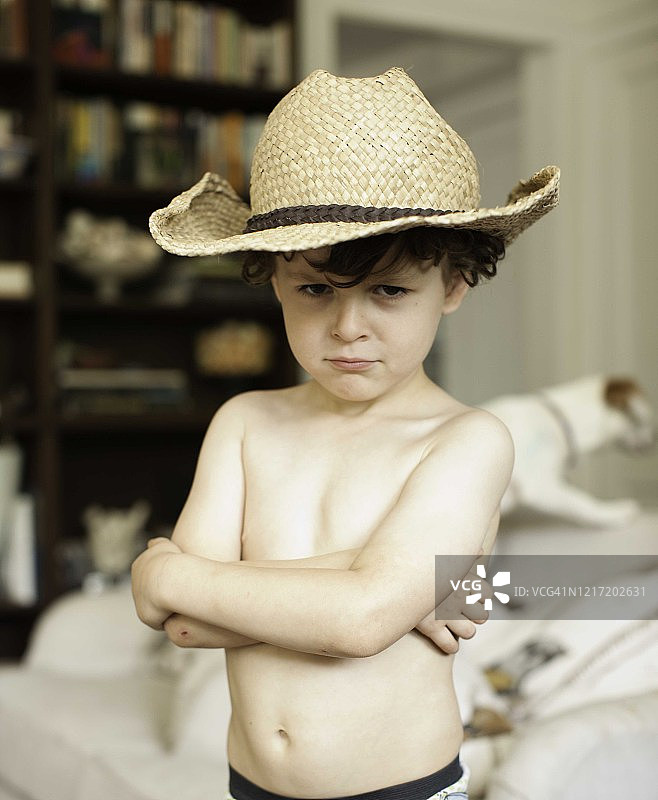 年幼的小男孩，棕色卷发，棕色眼睛，戴着牛仔帽看着镜头图片素材